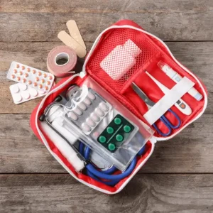 An emergency first aid kit placed on a wooden table, ready for use in case of medical emergencies.