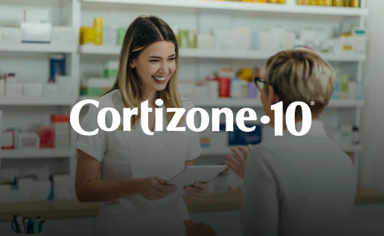 A pharmacist and a middle-aged woman talking in a pharmacy alley about Cortizone-10.